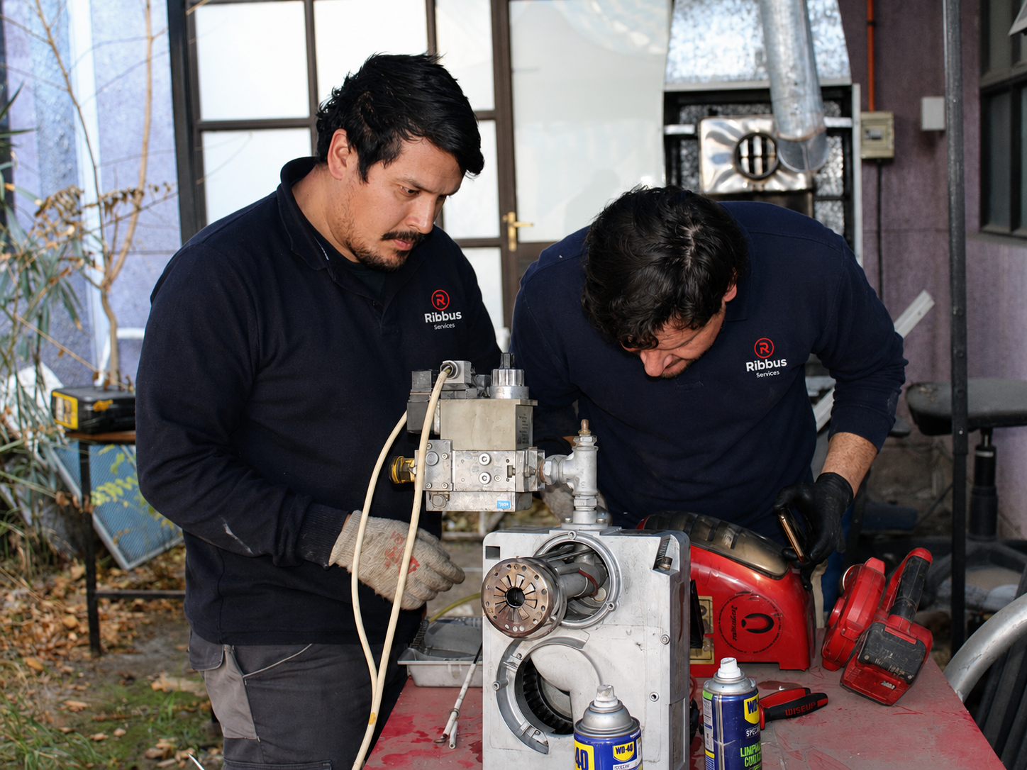 Dos técnicos de Ribbus Services interviniendo un equipo de climatización.